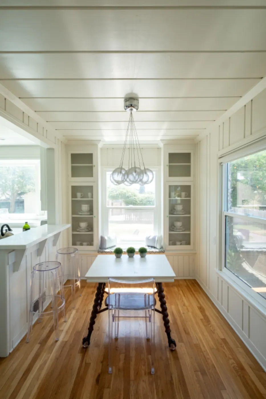 A long room with wood floors and built-in cabinets at the far end