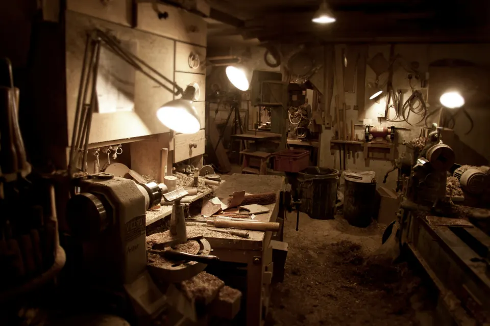 A woodworking shop lit by work lamps, full of tools