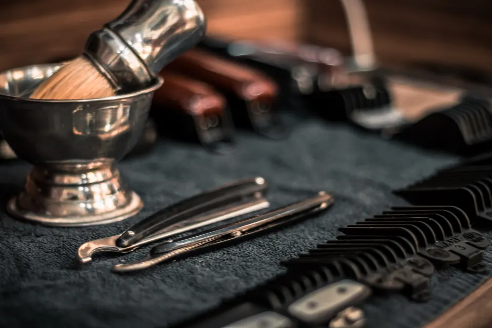 Clippers, a razor and a shaving brush laid out on a towel