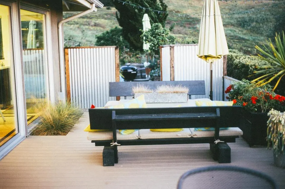 A finished backyard patio with outdoor seating beside the house
